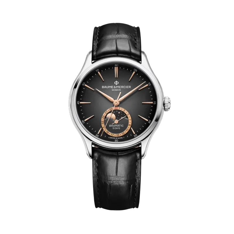 Baume & Mercier Clifton er en dressklokke med månefase til herre på 39 mm. Kasse i stål og rem i alligatorskinn. 50 meter vanntett.